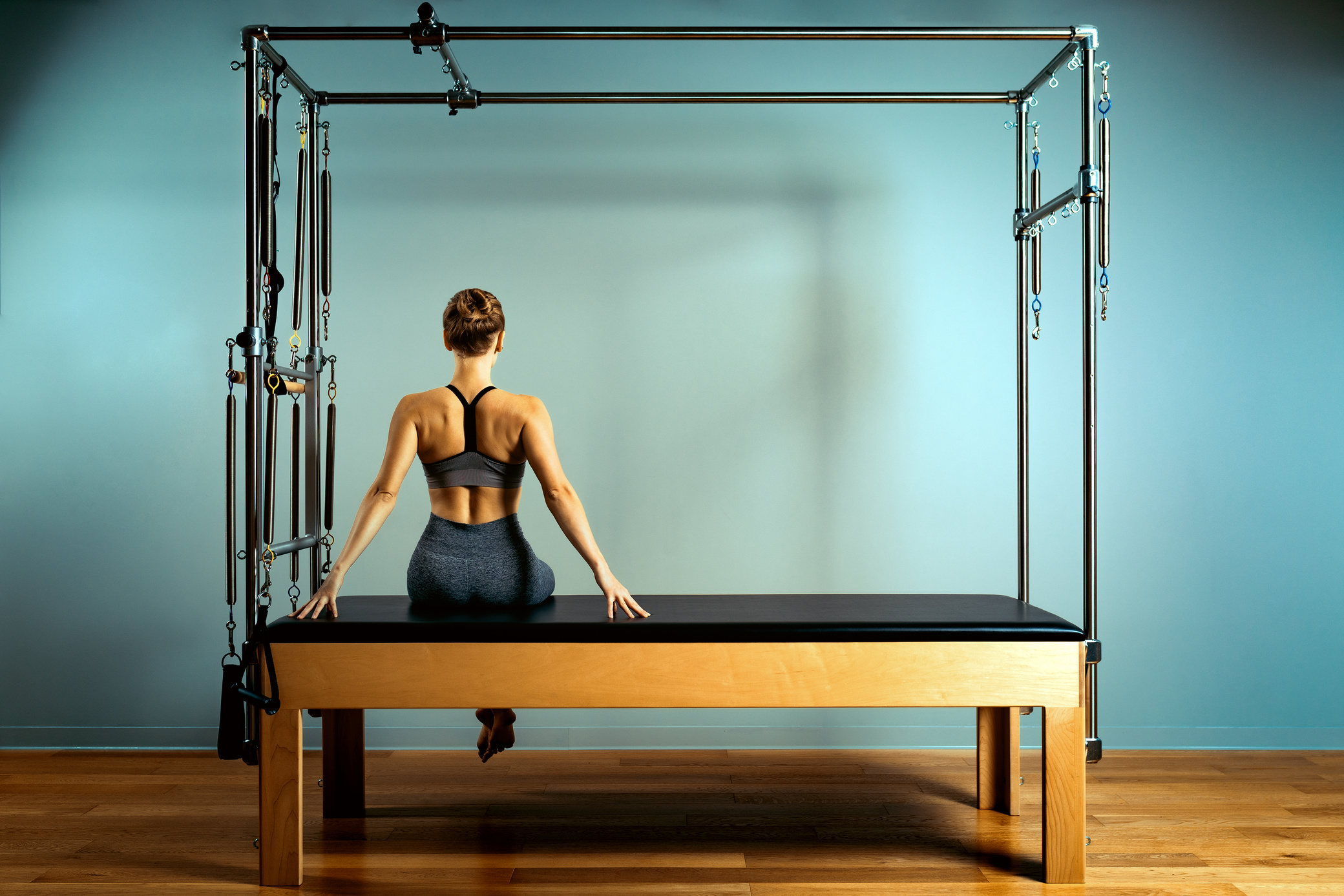 leotard workout pilates training. athletic pilates reformer exercises. pilates machine equipment. young woman pilates stretching sport in reformer bed instructor girl in a studio
